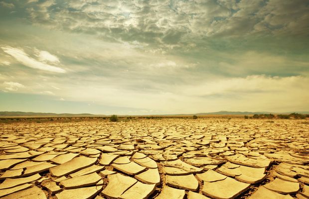 Cracked dry ground under heavy storm clouds