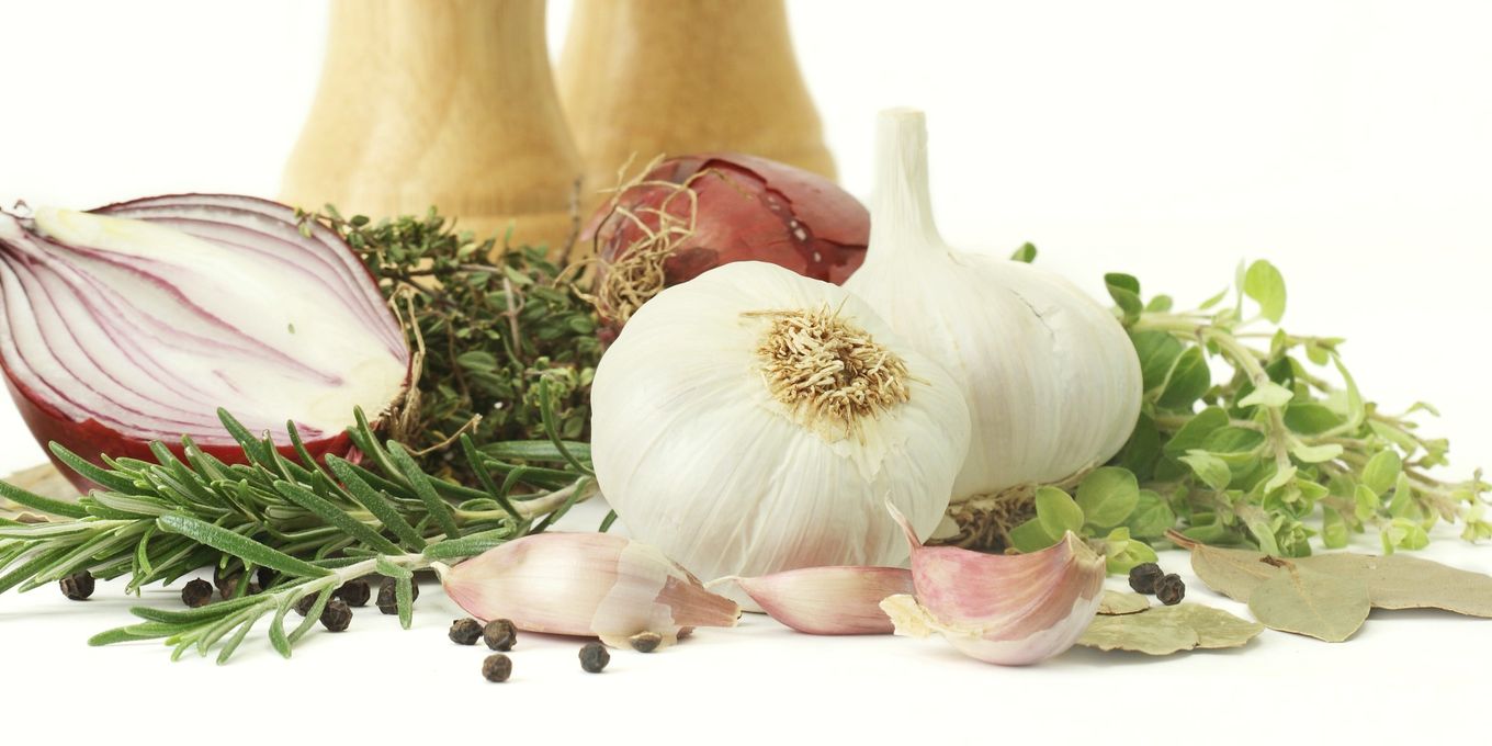A red onion, garlic bulbs and herbs